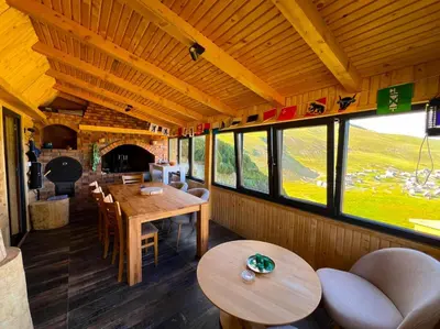 a dining room with tables and chairs and windows at BellaVista Prokosko Jezero in Paljike