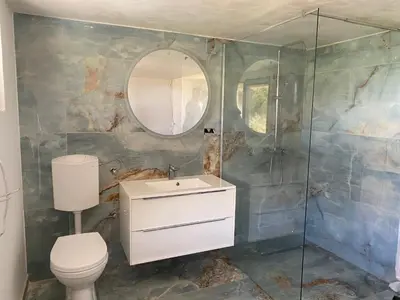 a bathroom with a toilet and a sink and a mirror at BellaVista Prokosko Jezero in Paljike