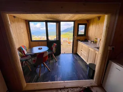 a small kitchen with a table and chairs in a cabin at BellaVista Prokosko Jezero in Paljike