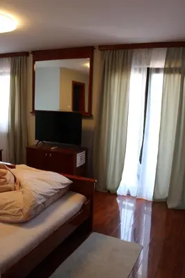 a bedroom with a bed and a large mirror at Intermezzo Vuk in Banja Luka