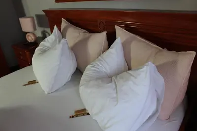 a bed with four pillows on top of it at Intermezzo Vuk in Banja Luka