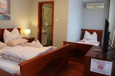 a bedroom with two beds and a flat screen tv at Intermezzo Vuk in Banja Luka