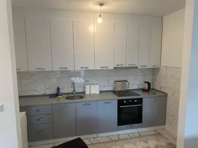 a kitchen with white cabinets and a sink at Stan Živinice in Živinice