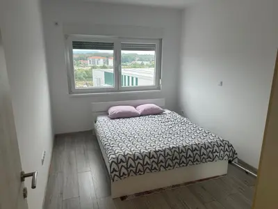a small bed in a room with a window at Stan Živinice in Živinice