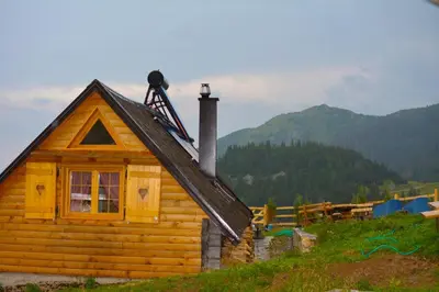 a log cabin with a chimney on top of it at BellaVista Srce Prokosko Jezero in Fojnica