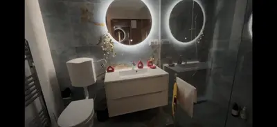 a bathroom with a toilet and a sink and two mirrors at BellaVista Srce Prokosko Jezero in Fojnica