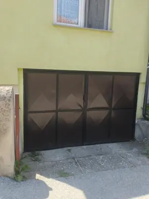 a large black garage door on the side of a building at Apartment Miki in Visoko