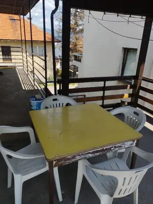 a wooden table and chairs on a balcony at Apartment Miki in Visoko