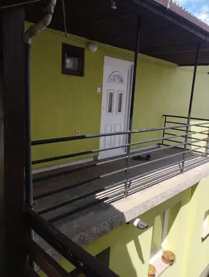 a front porch of a green house with a white door at Apartment Miki in Visoko