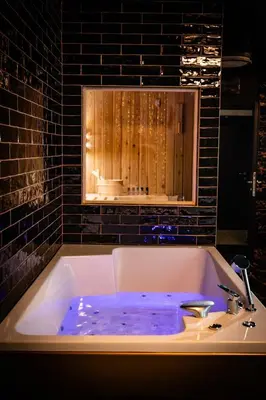 a bath tub with blue water in a bathroom at Spa centar LUX Doboj in Doboj