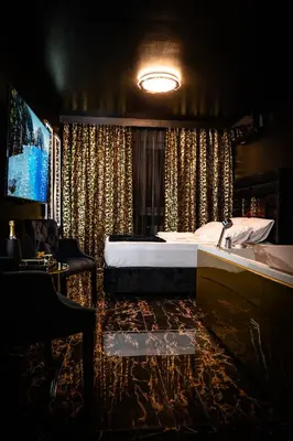a bedroom with a bed and a tub and a sink at Spa centar LUX Doboj in Doboj