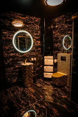 a bathroom with black stone walls and a mirror at Spa centar LUX Doboj in Doboj