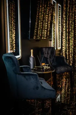 two chairs and a table in a room with lights at Spa centar LUX Doboj in Doboj