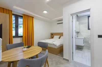 a hotel room with a bed and a table and chairs at Apartments River in Visoko