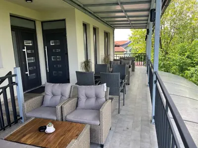 a patio with chairs and a table on a balcony at Apartments River in Visoko
