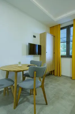 a dining room with a wooden table and chairs at Apartments River in Visoko