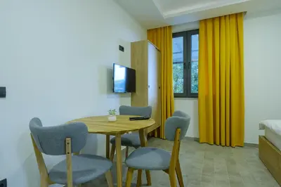 a room with a table and chairs and a bed at Apartments River in Visoko