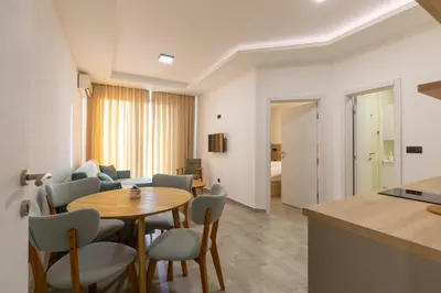 a kitchen and living room with a table and chairs at Apartments River in Visoko