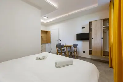 a bedroom with a bed and a table with chairs at Apartments River in Visoko