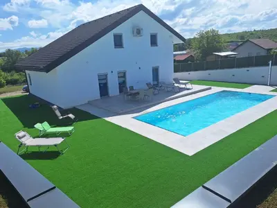 a house with a swimming pool and green grass at Vila Pascha in Zlopoljac