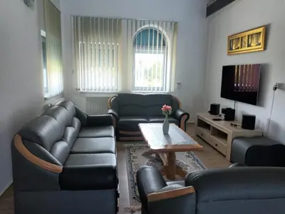 a living room with couches and a table and a tv at Vila Pascha in Zlopoljac