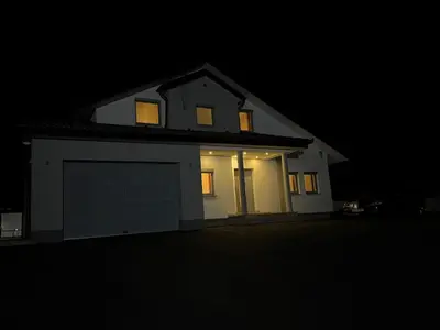 a white house with a garage at night at Vila Pascha in Zlopoljac