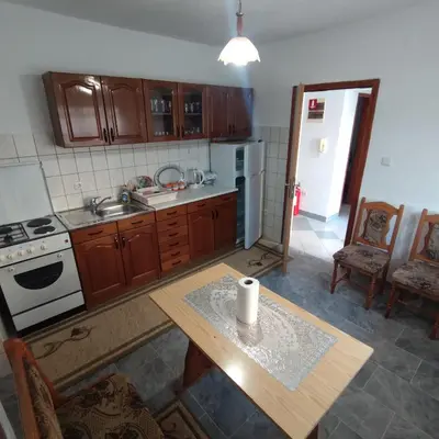 a kitchen with a table and a stove and refrigerator at Prenoćiste Borik in Sanski most