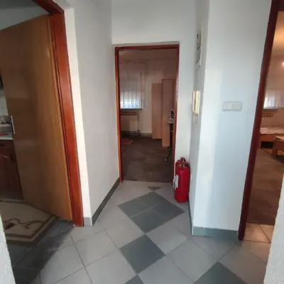 a hallway with a door and a red suitcase at Prenoćiste Borik in Sanski most