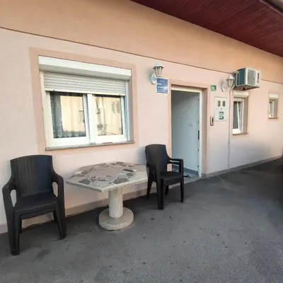 a patio with two chairs and a table and a window at Prenoćiste Borik in Sanski most
