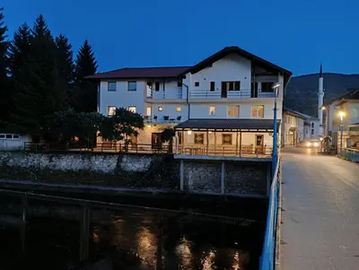 a building next to a river at night at Villa Medo in Kulen Vakuf