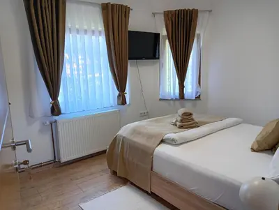 a bedroom with a bed and two windows at Villa Medo in Kulen Vakuf