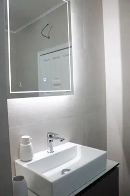 a bathroom with a white sink and a mirror at Royal Apartment in Banja Luka