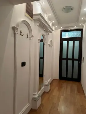 a hallway with a black door and a wooden floor at Royal Apartment in Banja Luka