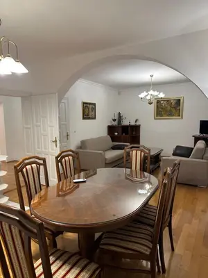 a dining room and living room with a table and chairs at Royal Apartment in Banja Luka