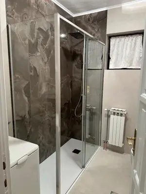 a shower with a glass door in a bathroom at Royal Apartment in Banja Luka