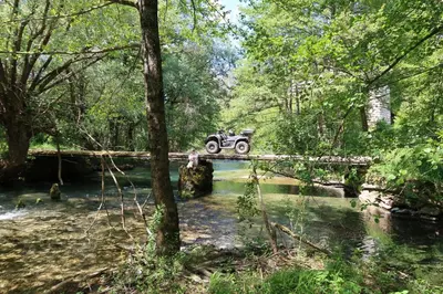 a jeep crossing a bridge over a river at Apartments Bioland in Kulen Vakuf