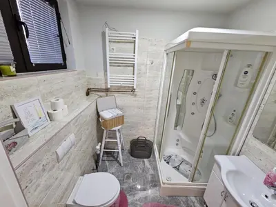 a bathroom with a shower and a toilet and a sink at Apartmani EMA Bihać in Bihać