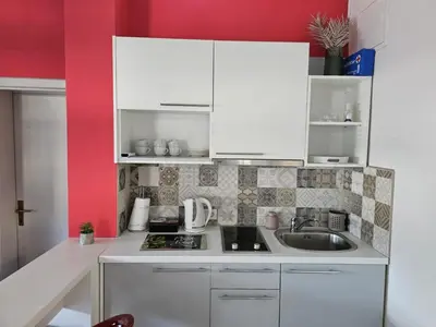 a small kitchen with white cabinets and a sink at Apartmani EMA Bihać in Bihać