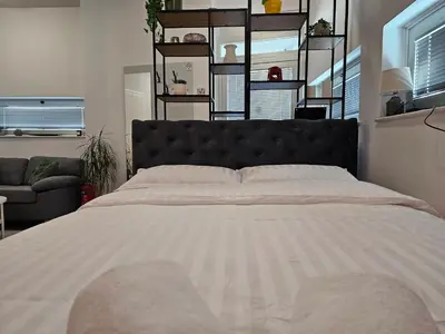 a large bed with a black headboard in a bedroom at Apartmani EMA Bihać in Bihać