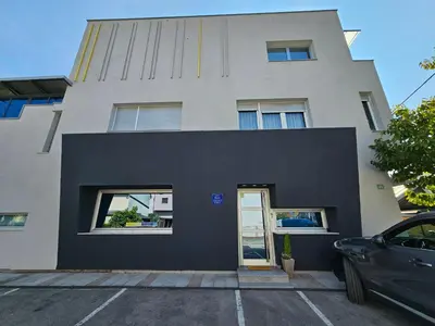 a black and white building with a door at Apartmani EMA Bihać in Bihać