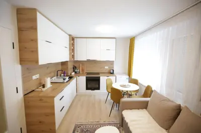 a kitchen and living room with a couch and a table at Apartman Centar in Fojnica