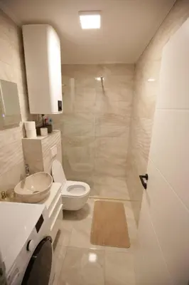 a white bathroom with a toilet and a sink at Apartman Centar in Fojnica
