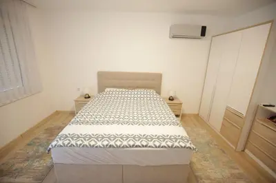 a bedroom with a bed in a white room at Apartman Centar in Fojnica