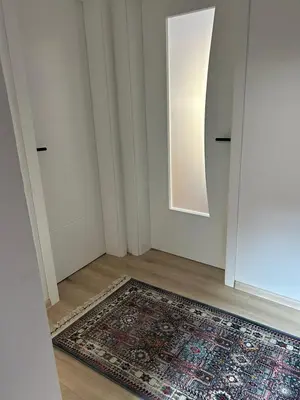 an empty room with a rug on the floor and a mirror at Apartman Centar in Fojnica