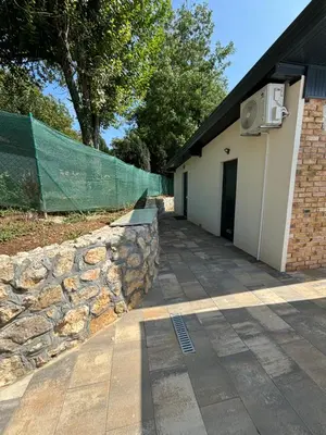 a stone retaining wall next to a building at Holiday Home Silenzio in Bihać