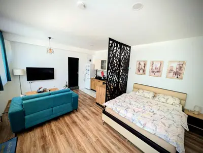 a bedroom with a bed and a blue couch at Apartmani Dinarika in Livno