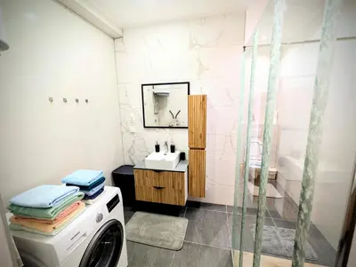 a bathroom with a washing machine and a sink at Apartmani Dinarika in Livno