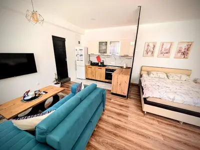 a living room with a blue couch and a bed at Apartmani Dinarika in Livno