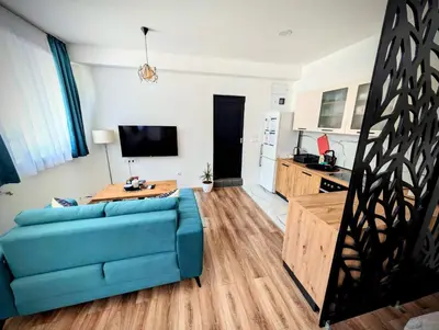 a living room with a blue couch and a kitchen at Apartmani Dinarika in Livno