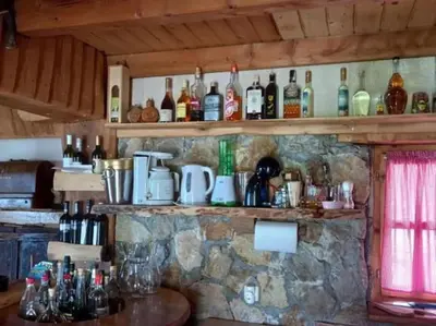 a bar with bottles of alcohol on a stone wall at Kuća za odmor Vidikovac in Rumboci